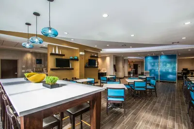 a lobby of a hotel with tables and chairs at Comfort Suites Fort Lauderdale Airport South & Cruise Port in Dania Beach
