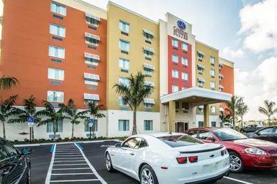 a white car parked in front of a hotel at Comfort Suites Fort Lauderdale Airport South & Cruise Port in Dania Beach