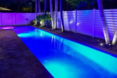 a swimming pool lit up at night with blue lights at Fort Lauderdale Oasis with Pool about 2 Mi to Beach! in Fort Lauderdale