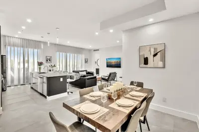 a dining room and living room with a table and chairs at Ocean Wave Deluxe Brand New Apartments in Fort Lauderdale