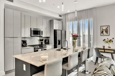 a kitchen with a large island with white cabinets at Ocean Wave Deluxe Brand New Apartments in Fort Lauderdale