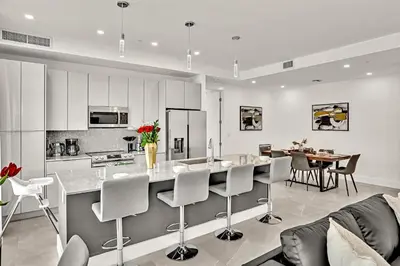 a kitchen and living room with a table and chairs at Ocean Wave Deluxe Brand New Apartments in Fort Lauderdale