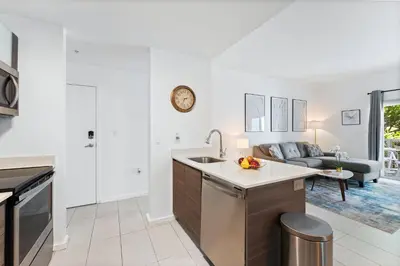 a kitchen with a sink and a living room at Modern apartment in Edgewater in Miami