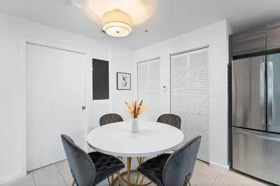 a white dining room with a white table and chairs at Modern apartment in Edgewater in Miami