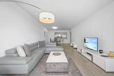 a living room with a couch and a tv at Spacious apartment of 2BR - 2BTH in Ocean Reserv front the beach in Sunny Isles Beach