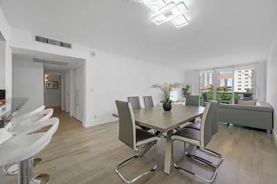 a dining room with a wooden table and chairs at Spacious apartment of 2BR - 2BTH in Ocean Reserv front the beach in Sunny Isles Beach