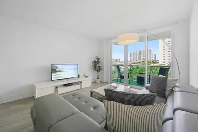 a living room with a couch and a tv at Spacious apartment of 2BR - 2BTH in Ocean Reserv front the beach in Sunny Isles Beach