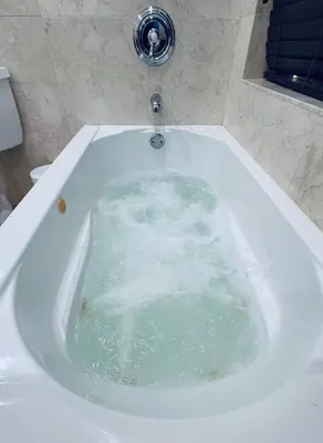 a bath tub filled with water in a bathroom at Cozy lakeside suite with private bath & entrance in Pembroke Pines