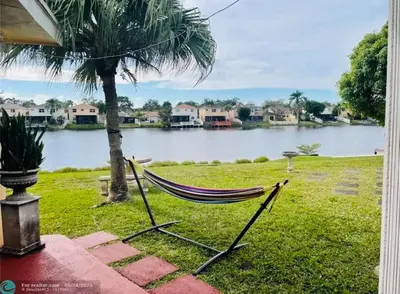 a hammock sitting on the grass next to a river at Cozy lakeside suite with private bath & entrance in Pembroke Pines