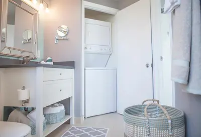 a bathroom with a sink and a washer and dryer at Connecting Rooms-Coconut Grove 10th Floor- Parking Included in Miami