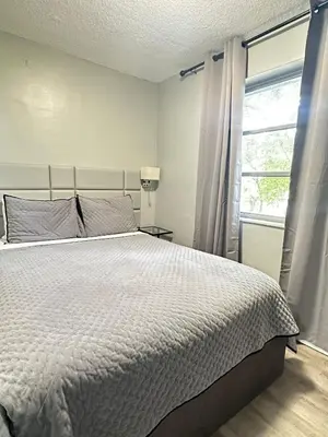 a bedroom with a large bed and a window at Sheridan Suites Apartments in Dania Beach