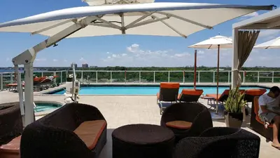 a patio with chairs and an umbrella and a pool at Coconut Grove 10th Fl Studio Parking Included in Miami