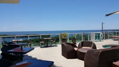 a patio with chairs and tables and a view of the ocean at Coconut Grove 10th Floor private unit Parking Included in Miami
