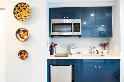 a kitchen with blue cabinets and a microwave at Deluxe Studio in Coconut Grove City and Bay views Includes Parking in Miami