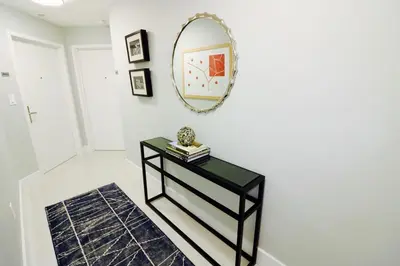a table with a mirror on a white wall at Connecting Rooms-Coconut Grove 21st Floor Parking Included in Miami