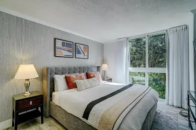 a bedroom with a bed and a large window at Cute 1 bedroom unit located in Condo Hotel in the heart of Coconut Grove Free Parking in Miami