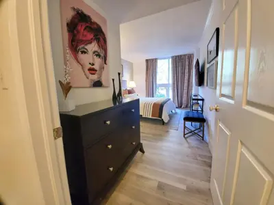 a bedroom with a dresser with a painting on the wall at Cute 1 bedroom unit located in Condo Hotel in the heart of Coconut Grove Free Parking in Miami