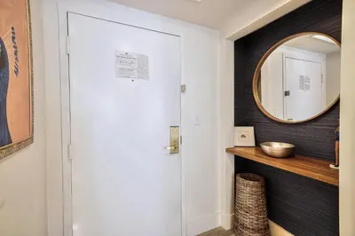 a hallway with a white door and a mirror at Cute 1 bedroom unit located in Condo Hotel in the heart of Coconut Grove Free Parking in Miami