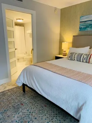 a bedroom with a large bed and a bathroom at Cozy 1 bedroom unit located in a Condo Hotel in the heart of Coconut Grove Free Parking in Miami