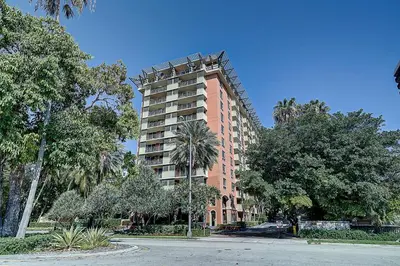 a tall pink building with trees in front of it at Coconut Grove Retreat 1 bedroom apartment with Bay views in Miami