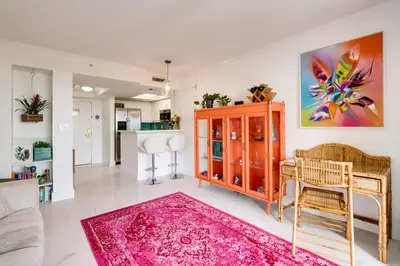 a living room with a red cabinet and a pink rug at Coconut Grove Retreat 1 bedroom apartment with Bay views in Miami