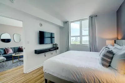a white bedroom with a bed and a tv at Coconut Grove 1 bedroom condo parking included in Miami