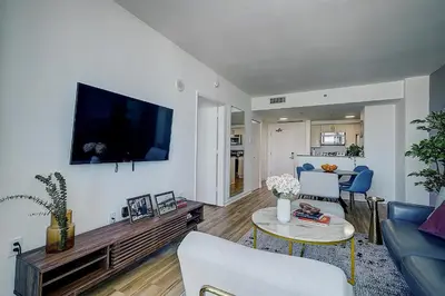 a living room with a couch and a tv on a wall at Coconut Grove 1 bedroom condo parking included in Miami