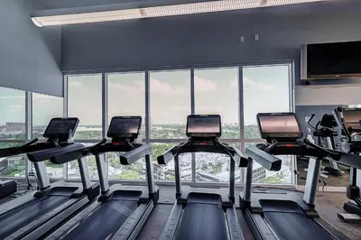 a gym with several treadmills in front of a large window at Coconut Grove 1 bedroom condo parking included in Miami