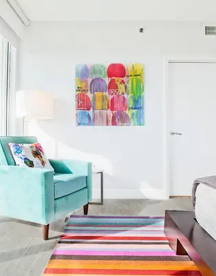 a living room with a blue chair and a colorful rug at Private 2 bedroom bay view condo in Coconut Grove includes parking in Miami