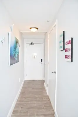a hallway with white walls and a white door at Private 2 bedroom bay view condo in Coconut Grove includes parking in Miami