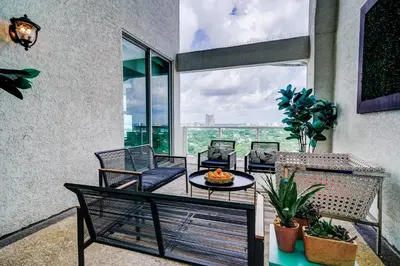a balcony with a table and chairs and a large window at Luxury 2-story Penthouse located in Coconut Grove Hotel-includes Parking in Miami