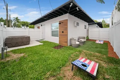 a small backyard with a house with a lawn at Modern Apt Near Las Olas Beach in Fort Lauderdale