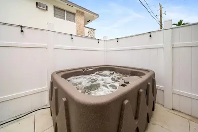 a bath tub sitting on the side of a white fence at Modern Apt Near Las Olas Beach in Fort Lauderdale