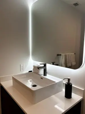 a bathroom with a white sink and a large mirror at Modern Studio Downtown with Pool and Gym in Miami