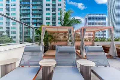 a patio with chairs and tables on a balcony with buildings at Modern Studio Downtown with Pool and Gym in Miami