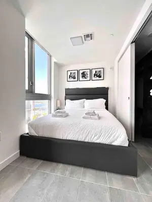 a bedroom with a large bed with a large window at Modern Studio Downtown with Pool and Gym in Miami