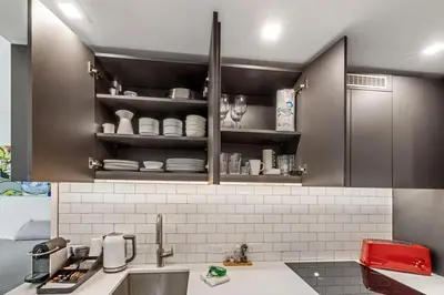 a kitchen with a sink and a shelf with dishes at Downtown Luxury Studio Pool and Gym in Miami