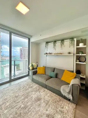 a living room with a couch and a large window at Ocean view Studio Pool and gym in Miami