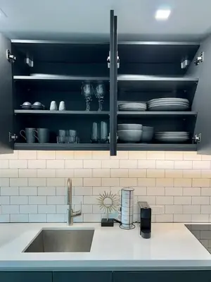 a kitchen counter with a sink and plates on shelves at Upscale Ocean View Studio Pool and Gym in Miami
