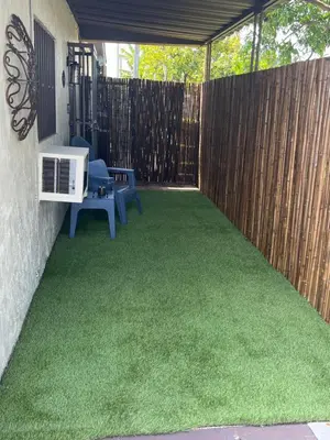 a backyard with a fence and green grass at cozy studio apartment with private entrance and patio in Miami