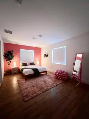 a bedroom with a bed and a red wall at Super stylish 4 BR Home Steps from the Fun in Fort Lauderdale