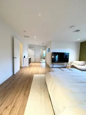 a large bedroom with a large bed and a flat screen tv at Super stylish 4 BR Home Steps from the Fun in Fort Lauderdale