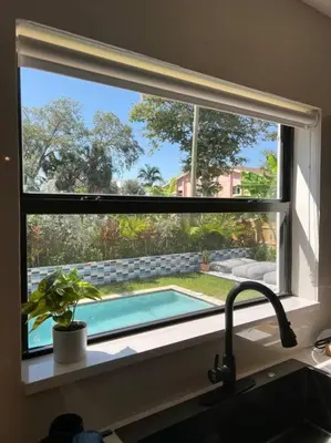 a window over a kitchen sink with a swimming pool at Super stylish 4 BR Home Steps from the Fun in Fort Lauderdale