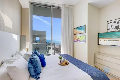 a bedroom with a bed with a large window at Spectacular ocean and beach view in Hollywood