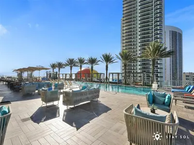 a swimming pool with chairs and a building at Spectacular ocean and beach view in Hollywood