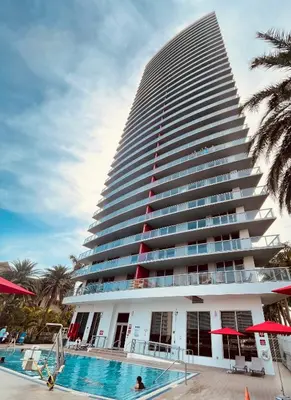a tall building with a swimming pool in front of it at Beachwalk Studio (Beach, Pool and Gym) in Hallandale Beach
