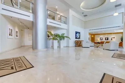 a large room with a lobby with white furniture at 2 BR Monthly beach condo Miami in Hallandale Beach