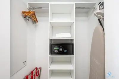 a closet with white shelves and a microwave and a surfboard at Beachwalk Resort: Amaizing View Balcony Gym Pool in Hallandale Beach