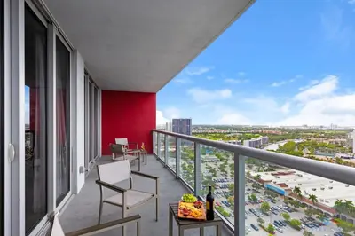 a balcony with chairs and a red wall at Beachwalk Resort: Amaizing View Balcony Gym Pool in Hallandale Beach