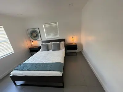 a bedroom with a bed with two tables and two lamps at Stylish Pool Home in Hollywood